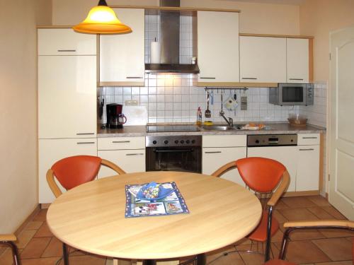 奥斯特西巴德钦诺维茨Apartment Lerche by Interhome的厨房配有木桌和四把椅子