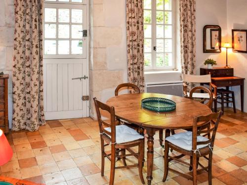 吕讷Holiday Home Le Coteau Fleury by Interhome的一间带木桌和椅子的用餐室