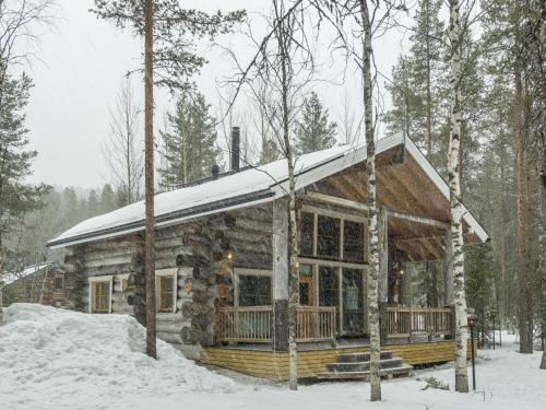 列维Holiday Home Kotkanpesä by Interhome的雪中树林里的小木屋
