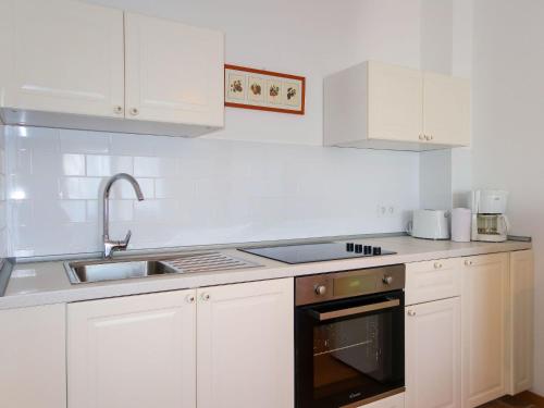 奈维斯Apartment Martina - NJI112 by Interhome的厨房配有白色橱柜、水槽和烤箱。