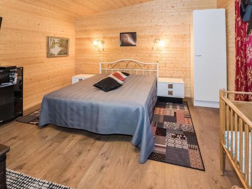 KelkalaHoliday Home Mäntymäki by Interhome的卧室配有一张床铺,位于带木墙的房间内