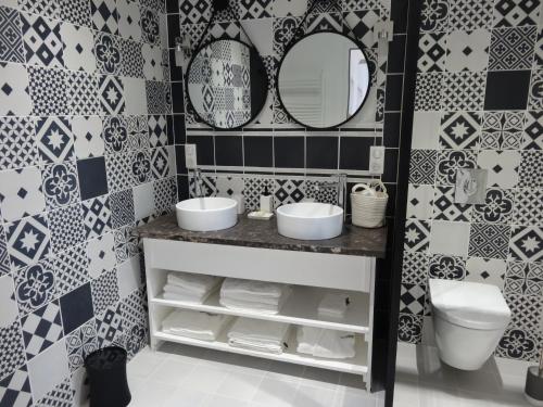 布雷索塞尼Les Petites Tuileries的浴室设有水槽、镜子和瓷砖