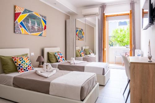 奥特朗托Vele d'Otranto B&B的一间卧室设有两张床、一张桌子和一个窗口