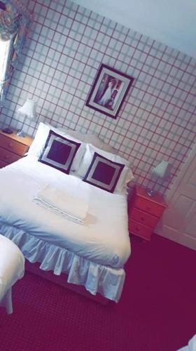 TrehafodBertie Pontypridd的卧室配有一张床,墙上挂有两张照片