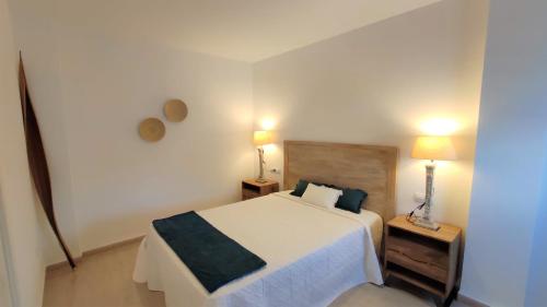 科尼尔-德拉弗龙特拉La Rotonda Penthouse的一间卧室配有一张床和两个带灯的床头柜