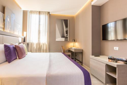 罗马奥拉齐奥皇宫酒店的酒店客房设有一张大床和一台电视。