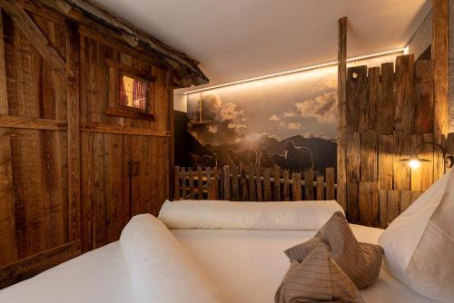 科尔皮缇亚Sonnleiten Sonnenalm的卧室配有白色的床和墙上的绘画作品