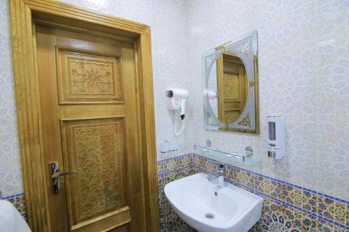 布哈拉Xadijam Hotel的一间带水槽、镜子和门的浴室