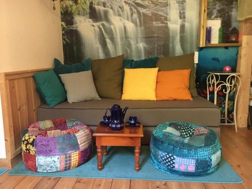 Kfar YonaThe fruit garden guesthouse的客厅配有沙发和两把脚凳