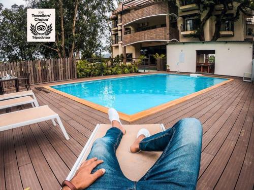 伯杰默里The Summer House, Pachmarhi - AM Hotel Kollection的躺在游泳池旁躺椅上的女人