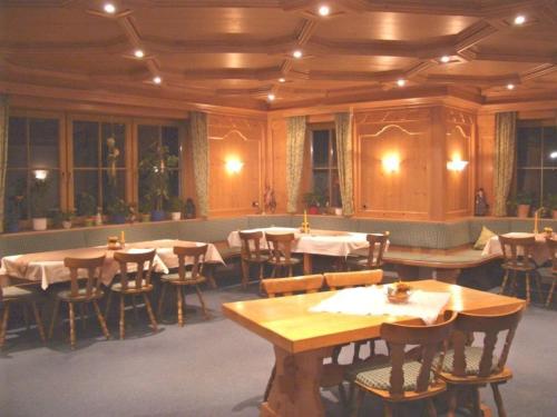 塞埃巴克鲍尔勒霍夫旅馆的用餐室配有木桌和椅子