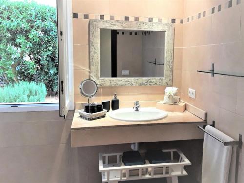 马纳科尔Apartment En Capillo的一间带水槽和镜子的浴室以及窗户。