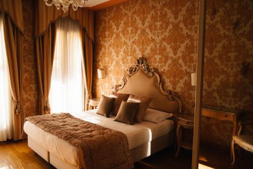 穆拉诺穆拉诺皇宫酒店的一间卧室设有一张床和一个窗口
