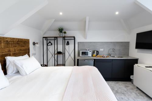 法尔茅斯Park View的一间带白色床的卧室和一间厨房