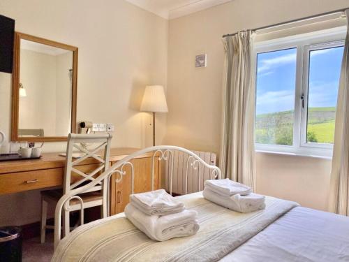 阿伯里斯特威斯勒提赛罗旅馆的一间卧室配有一张带书桌和镜子的床
