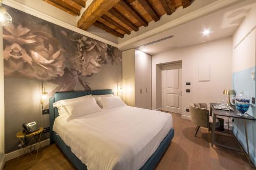 皮斯托亚Palazzo 42 - Boutique Hotel & Suites的一间卧室配有一张大床和一张书桌