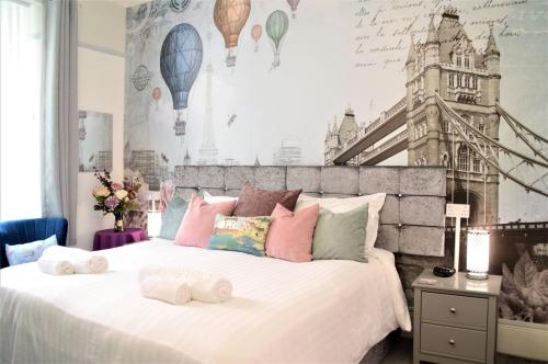 佩恩顿圣埃德蒙兹宾馆的一间卧室设有一张大床和一堵带城市图画的墙壁