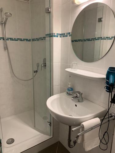 博尔肯豪斯沃德施餐厅酒店的浴室配有盥洗盆和带镜子的淋浴