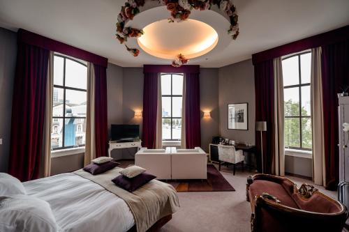 鹿特丹品克弗套房酒店的一间卧室配有一张大床和一个吊灯。