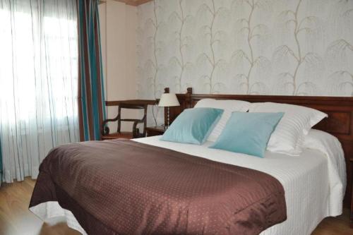 坎普罗东Hotel Edelweiss的一间卧室配有一张带蓝色枕头的大床