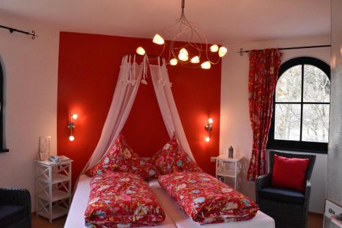 伦斯泰格地区施米德费尔德卡斯汀格尔酒店餐厅的一间卧室设有红色的墙壁和一张带红色枕头的床