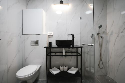 阿什杜德Unique Hotel Ashdod的白色的浴室设有卫生间和淋浴。