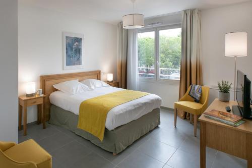 马赛DOMITYS LA BADIANE的一间卧室配有一张床、一张书桌和一个窗户。
