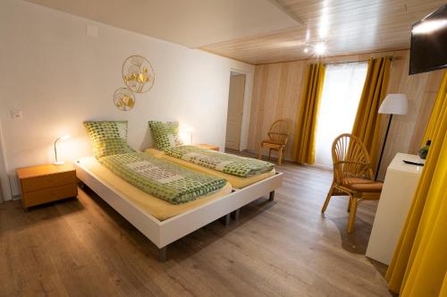 赛尼厄莱吉耶Hôtel Bellavista "Bellevue"的一间卧室配有两张带绿色枕头的床
