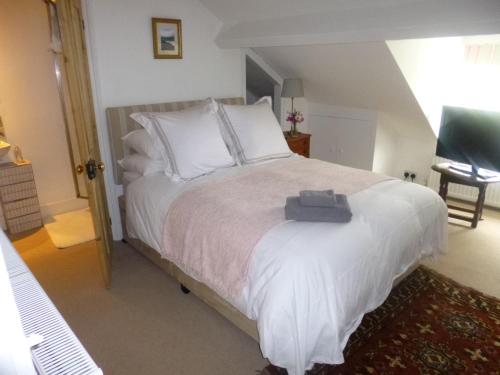 瓦灵福德Cranberry Cottage的卧室配有带白色枕头的大床
