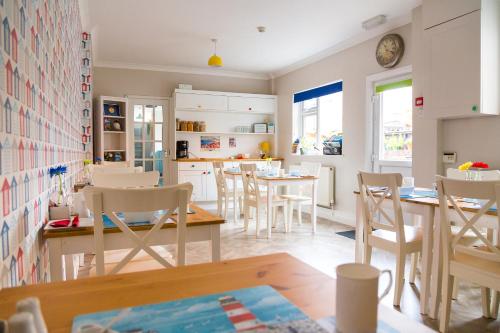 斯卡伯勒Kingsway Guesthouse - A selection of Single, Double and Family Rooms in a Central Location的厨房以及带桌椅的用餐室。