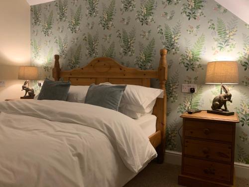 霍舍姆Lancasters Cottage的卧室配有一张挂着绿叶的墙壁床。