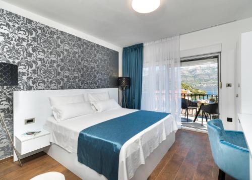科尔丘拉WISH Apartments的一间卧室配有一张带蓝色毯子的床和窗户。