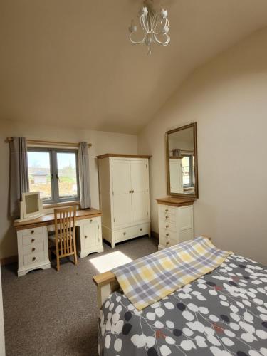 Over KelletSwallow cottage, Over Kellet的一间卧室配有一张床、一张书桌和一面镜子