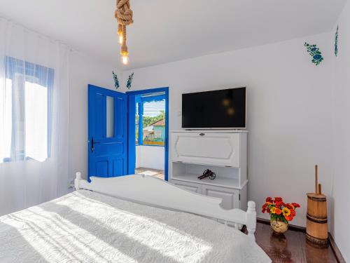 SchiuleştiCasa de vacanta traditionala romaneasca的一间白色卧室,配有一张床和一个蓝色的门