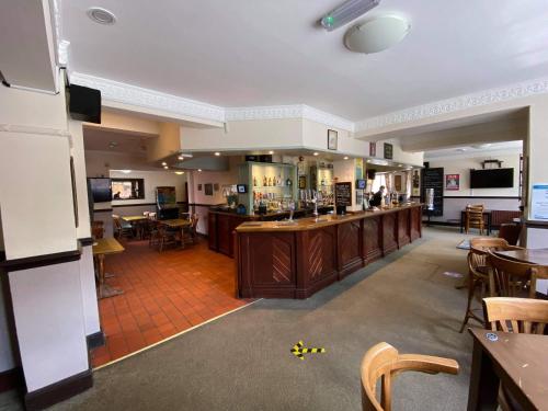 Wigston MagnaThe Plough Inn Wigston的大房间设有酒吧和一些桌椅