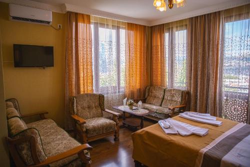 第比利斯Family Hotel Kolorit Old Tbilisi的酒店客房带一张床、一张桌子和椅子
