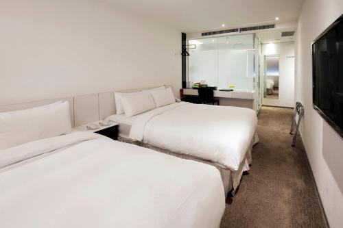 台北新驛旅店台北車站三館的酒店客房,设有两张床和镜子
