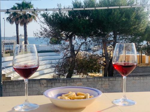 托雷圣乔万尼乌SoleSalento 32的两杯葡萄酒和一碗桌上的食物