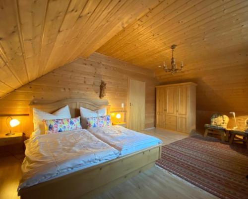 PflachFerienwohnung Lechglück的一间卧室设有一张带木制天花板的大床