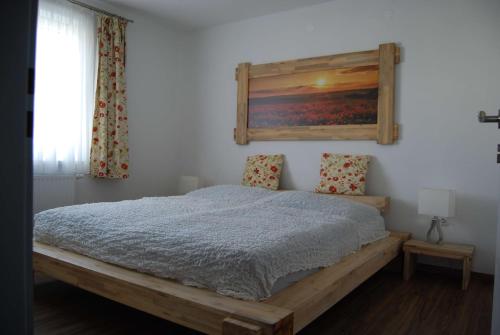 Hörmanns bei WeitraFerienwohnung Polzer的卧室配有一张床,墙上挂有绘画作品