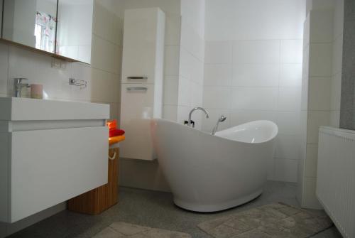 Hörmanns bei WeitraFerienwohnung Polzer的白色的浴室设有浴缸和水槽。