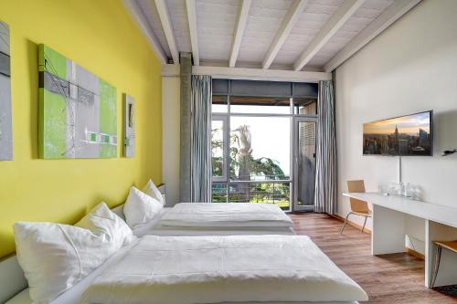 罗尔沙赫伯格Schloss Wartensee的一间卧室设有两张床和黄色的墙壁