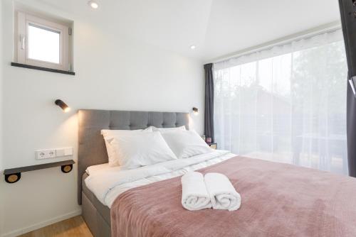 派尔努Villa Aia Apartment的一间卧室配有一张大床和两条毛巾