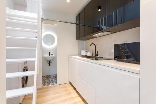派尔努Villa Aia Apartment的白色的厨房设有水槽和台面
