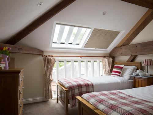 温什科姆Oliver Cromwell的阁楼卧室设有两张床和天窗