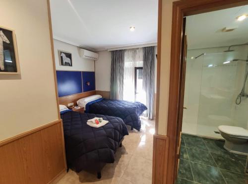 托莱多Trípolis Toledo的酒店客房设有两张床和淋浴。