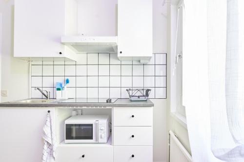 阿沃斯塔Folkarbo Vandrarhem的厨房配有白色橱柜和微波炉