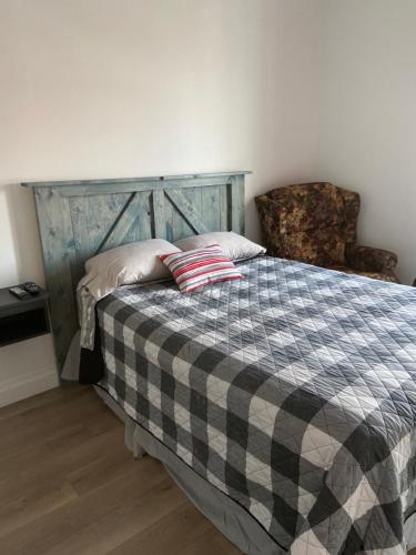 拉图克Gestion clin d'oeil - 503的一间卧室配有一张带 ⁇ 子毯子和椅子的床