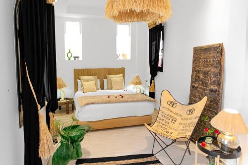 马拉喀什利马尔庭院旅馆的一间卧室配有一张床和一把椅子