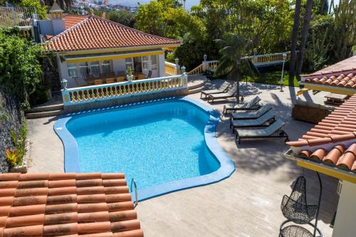 拉奥罗塔瓦Balcón del Teide的一个带椅子的游泳池以及一座房子